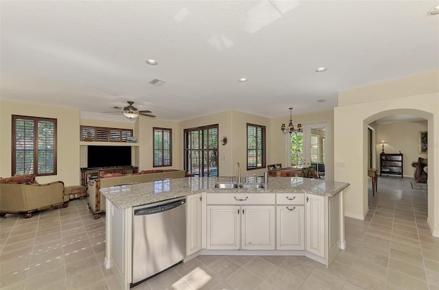 kitchen with a kitchen island with sink, a healthy amount of sunlight, sink, stainless steel dishwasher, and white cabinets