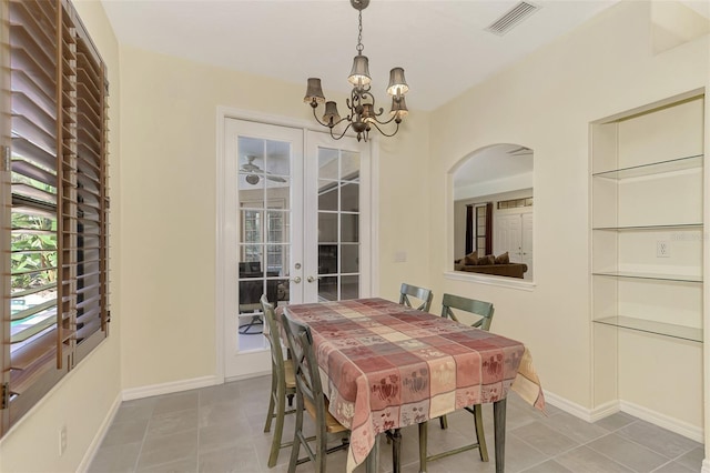 tiled dining space featuring french doors and a chandelier