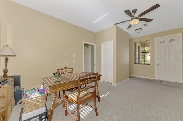 carpeted dining room with ceiling fan