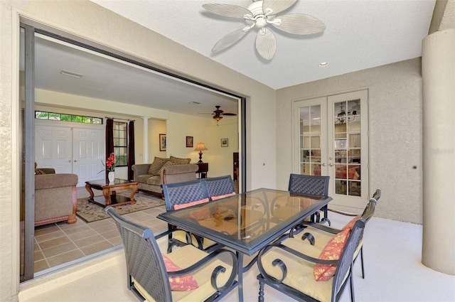 dining room with a textured ceiling, light tile patterned floors, ornate columns, and ceiling fan