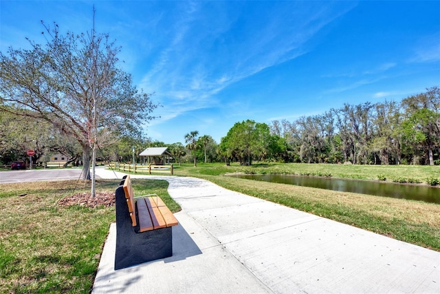 view of property's community featuring a water view and a lawn