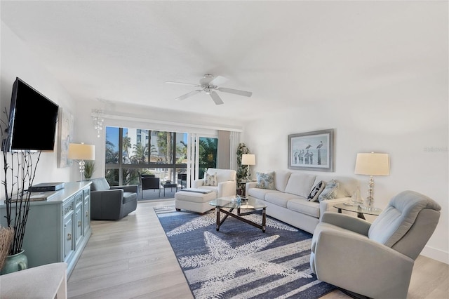 living room with ceiling fan and light hardwood / wood-style flooring