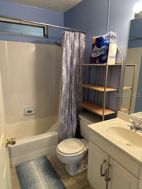 full bathroom featuring a textured ceiling, toilet, tile patterned floors, vanity, and shower / bathtub combination with curtain