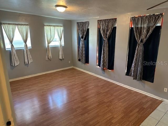 empty room with a textured ceiling and hardwood / wood-style floors