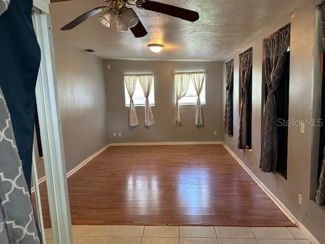 empty room with ceiling fan and light hardwood / wood-style flooring