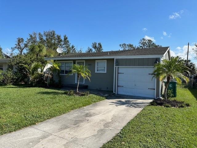 single story home with a front yard and a garage