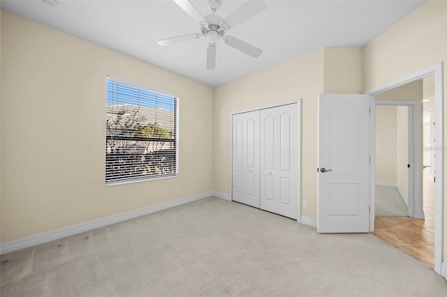 unfurnished bedroom with ceiling fan, light carpet, and a closet