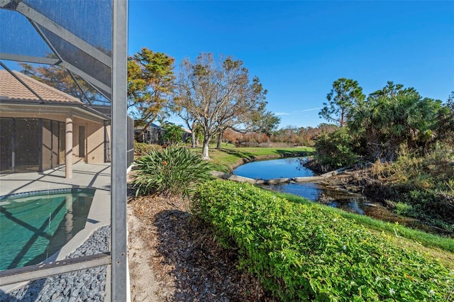 view of yard featuring glass enclosure and a water view