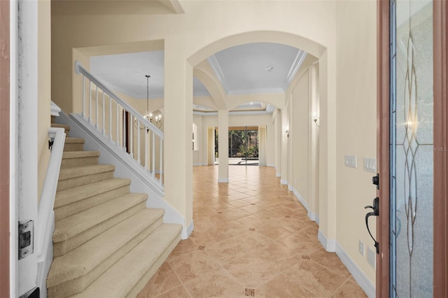 foyer with crown molding, a notable chandelier, arched walkways, baseboards, and light tile patterned floors