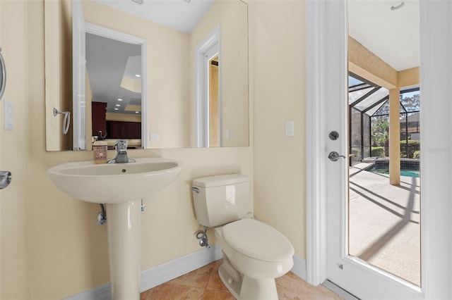 half bath with baseboards, tile patterned flooring, and toilet