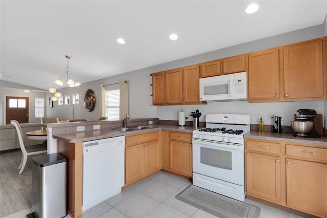 kitchen featuring kitchen peninsula, sink, vaulted ceiling, a notable chandelier, and white appliances