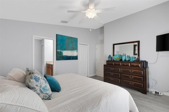 bedroom featuring light wood-type flooring, a closet, ceiling fan, vaulted ceiling, and connected bathroom