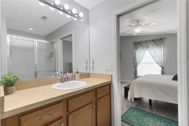 bathroom with vanity, ceiling fan, wood-type flooring, and an enclosed shower