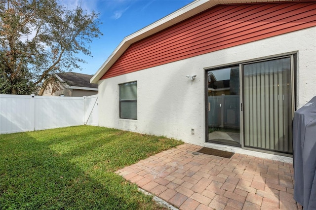 back of property featuring a patio area and a yard