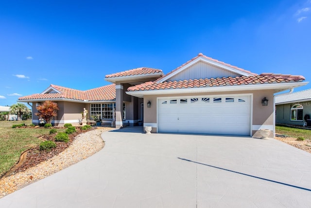 view of front of home featuring a tile roof, driveway, an attached garage, and stucco siding