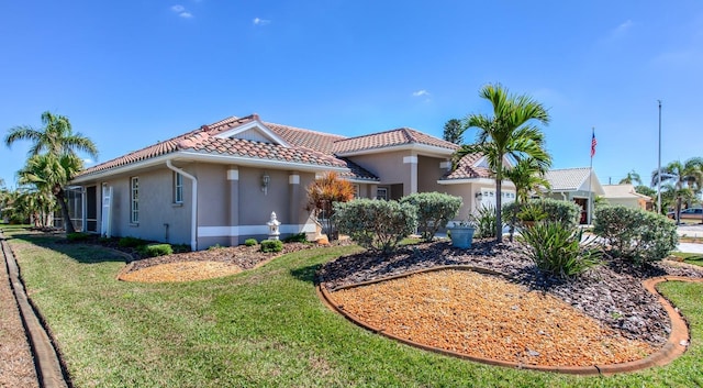 mediterranean / spanish-style house with a front lawn, a tile roof, an attached garage, and stucco siding