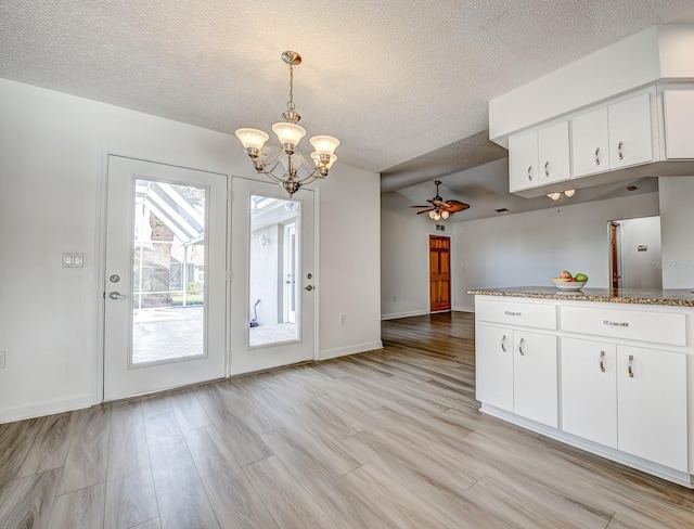 kitchen featuring light wood finished floors, pendant lighting, and white cabinets