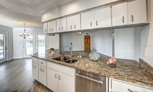 kitchen with decorative light fixtures, dark wood finished floors, white cabinets, a sink, and dishwasher