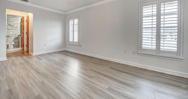 unfurnished room featuring light wood-style flooring, visible vents, baseboards, and crown molding