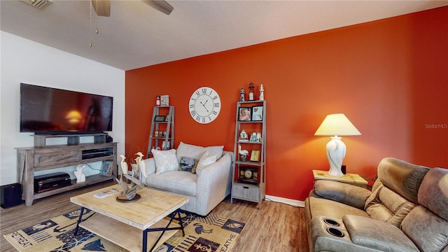 living room featuring wood-type flooring and ceiling fan