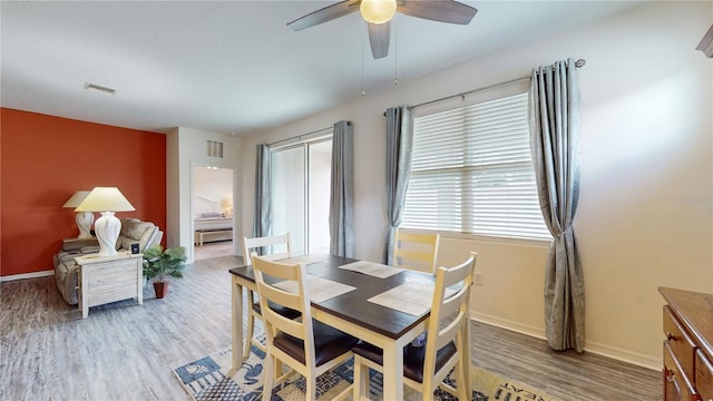 dining space with light hardwood / wood-style floors and ceiling fan