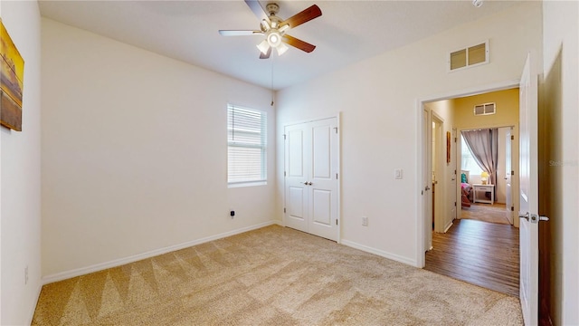 unfurnished bedroom with light hardwood / wood-style floors, a closet, and ceiling fan