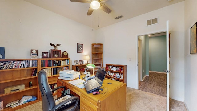 carpeted office space with ceiling fan