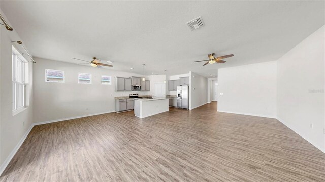 3718 Mossy Limb Ct, Palmetto, FL 34221 - unfurnished living room with a ceiling fan, light wood-style flooring, and baseboards