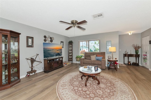 living room featuring light hardwood / wood-style floors and ceiling fan