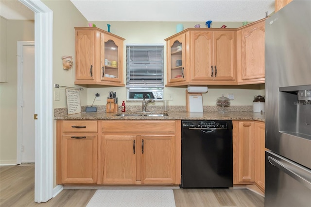 kitchen featuring light stone counters, dishwasher, light hardwood / wood-style floors, stainless steel refrigerator with ice dispenser, and sink