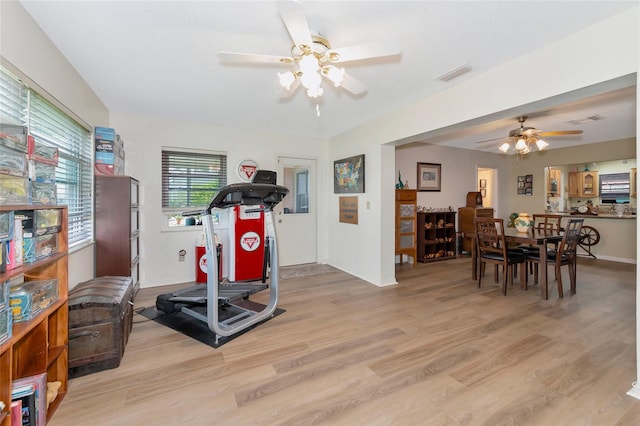 workout area with light wood-type flooring and ceiling fan