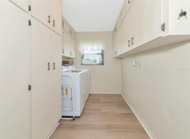 laundry area featuring cabinets, independent washer and dryer, and light wood-type flooring