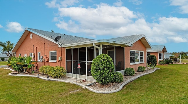 rear view of property with a yard and a sunroom