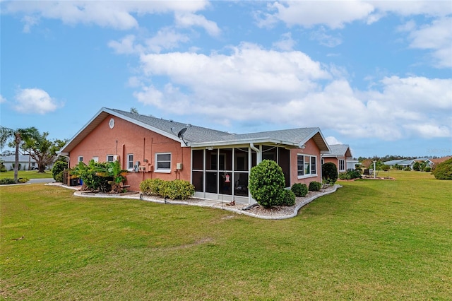 back of property featuring a lawn and a sunroom