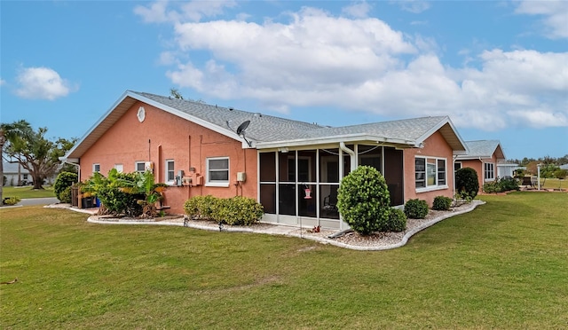 rear view of house with a lawn and a sunroom