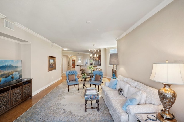 living room with wood-type flooring, crown molding, and a notable chandelier