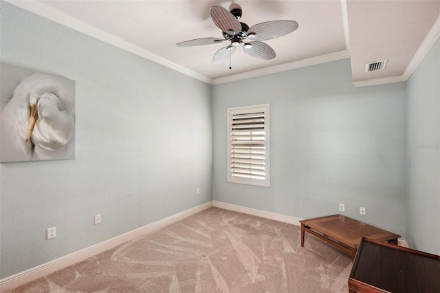 empty room featuring ceiling fan, light colored carpet, and crown molding