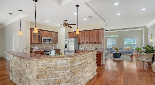 1789 Loma Linda St, Sarasota, FL 34239 - kitchen featuring visible vents, ornamental molding, brown cabinetry, and stainless steel appliances