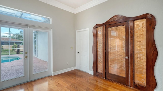 doorway to outside with light hardwood / wood-style floors, crown molding, and french doors