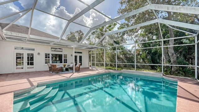 view of pool featuring french doors, a patio, and glass enclosure