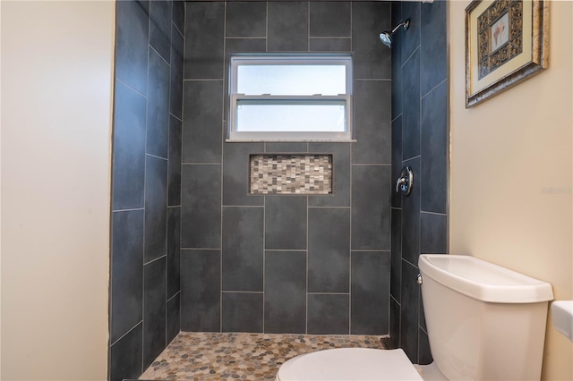 bathroom featuring toilet and tiled shower