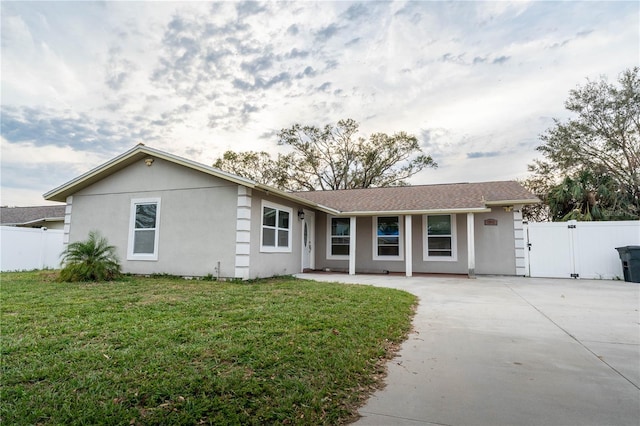 single story home featuring a front lawn and a patio