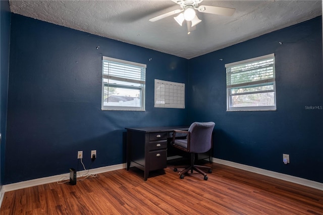 home office with hardwood / wood-style floors, ceiling fan, and a textured ceiling