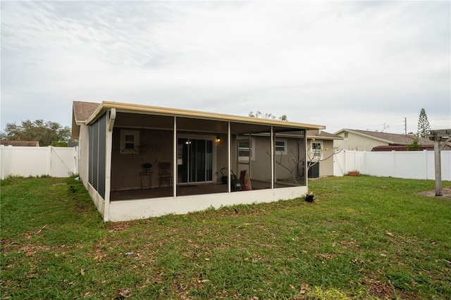 rear view of property featuring central AC, a sunroom, and a yard