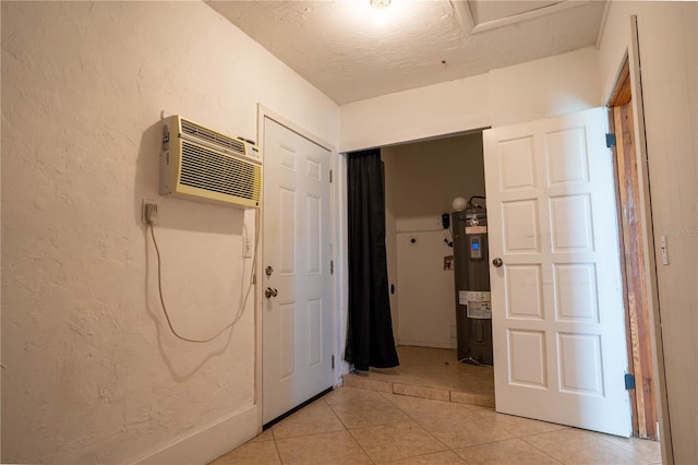 corridor featuring water heater, light tile patterned flooring, and a wall mounted air conditioner