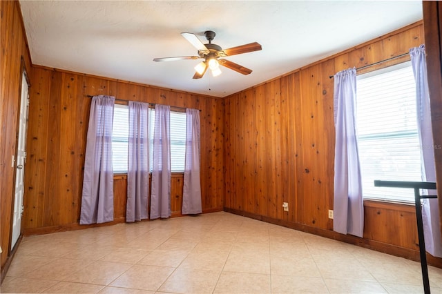 spare room with wooden walls and ceiling fan