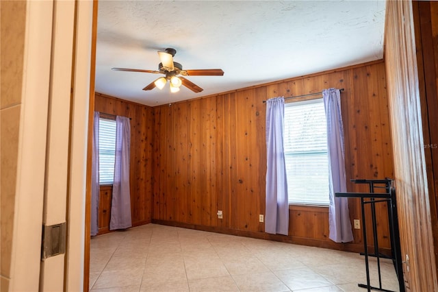 spare room with wooden walls and ceiling fan