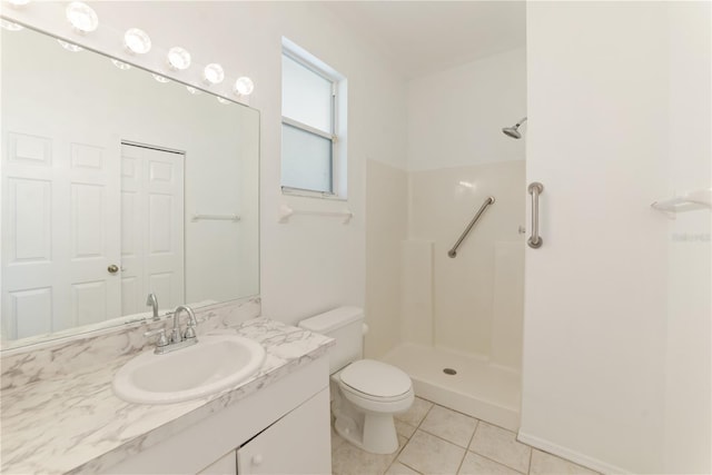 bathroom featuring toilet, walk in shower, vanity, and tile patterned flooring