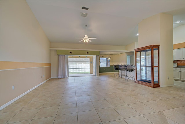 unfurnished living room with high vaulted ceiling, ceiling fan, and light tile patterned flooring