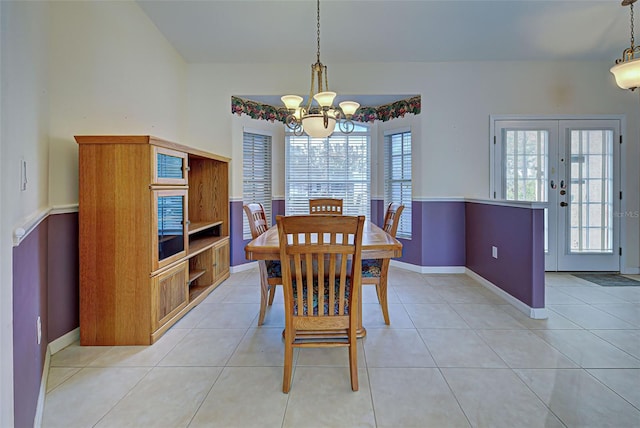 dining area with french doors, a notable chandelier, and light tile patterned flooring